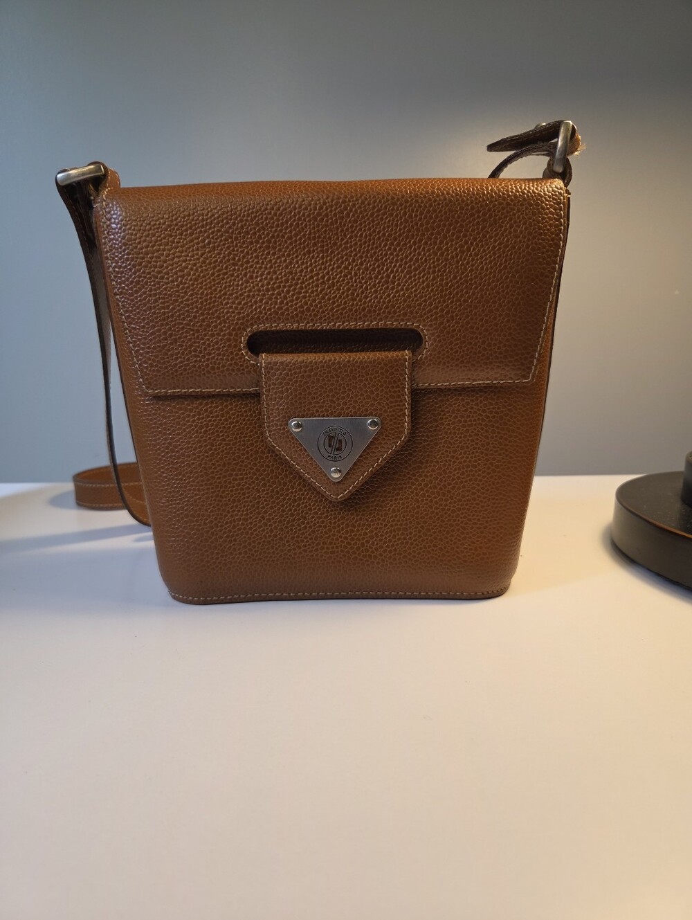 Renoma Paris crossbody bag is crafted from brown pebbled leather